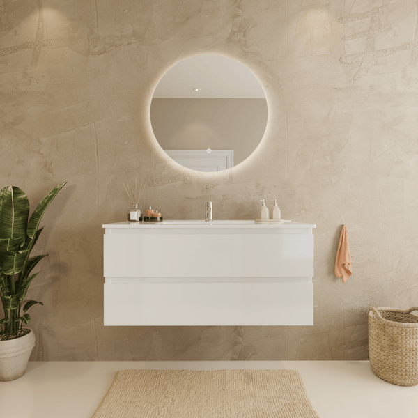 Modernes Badezimmer mit wandhängendem weißem Waschtischunterschrank, rundem LED-Spiegel und strukturierter Wand in Beige.