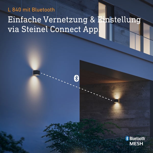 Zwei moderne Wandleuchten Steinel L 840 mit Bluetooth Vernetzung an einer Hausfassade bei Nacht.