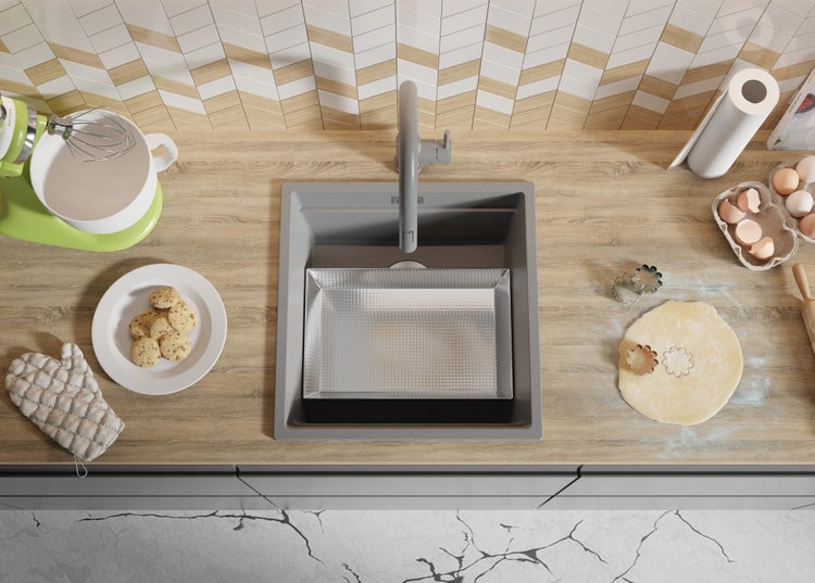 Küchenszene mit Spüle, Armatur, Teig, Keksen und Küchengeräten von oben.