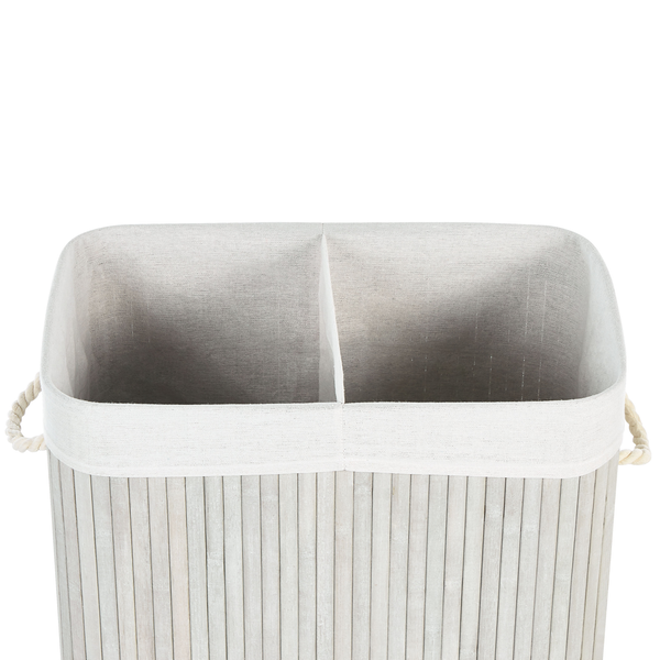 Wäschekorb aus hellem Bambus mit zwei Fächern, weißer Stoffeinlage und seitlichen Kordelgriffen.