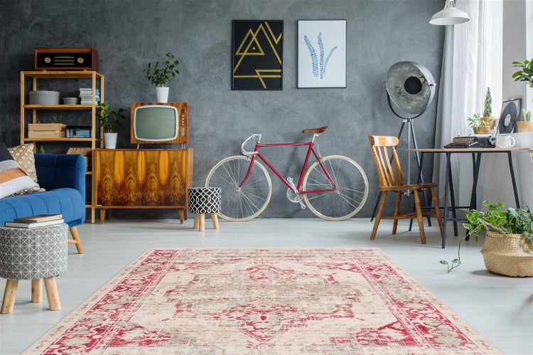 Orientteppich im Vintage-Stil in einem hellen Wohnzimmer mit Retro-Möbeln, einem roten Fahrrad und einer grauen Wand.