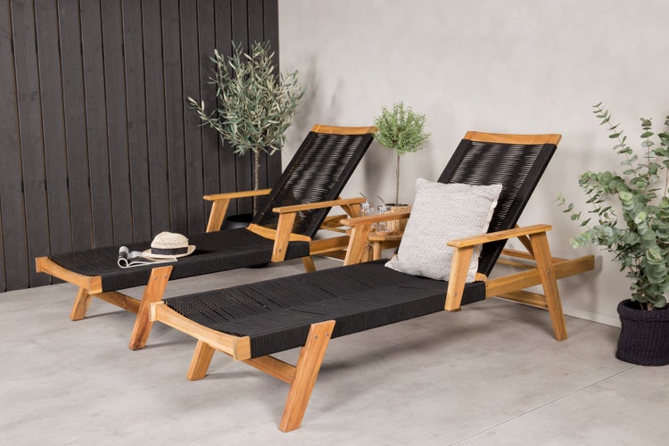 Zwei Holzliegen mit schwarzem Seilgeflecht auf einer Terrasse.
