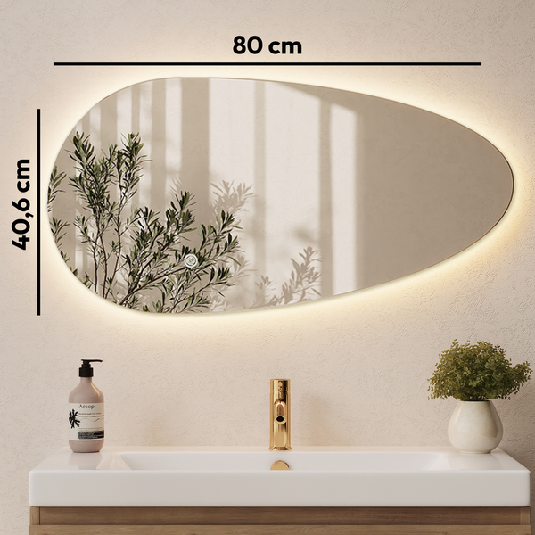Organisch geformter Wandspiegel mit LED Beleuchtung für das Badezimmer, Breite 80 Zentimeter, Höhe 40,6 Zentimeter, über einem Waschbecken.