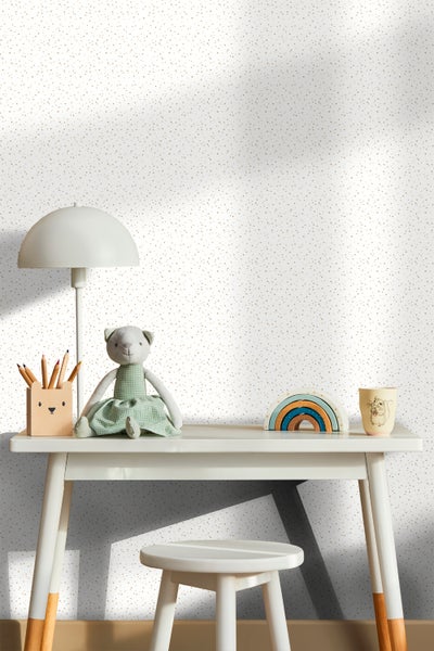 Dekoratives Kinderzimmer mit Schreibtisch, Stuhl und Spielzeug vor einer gemusterten Tapete.