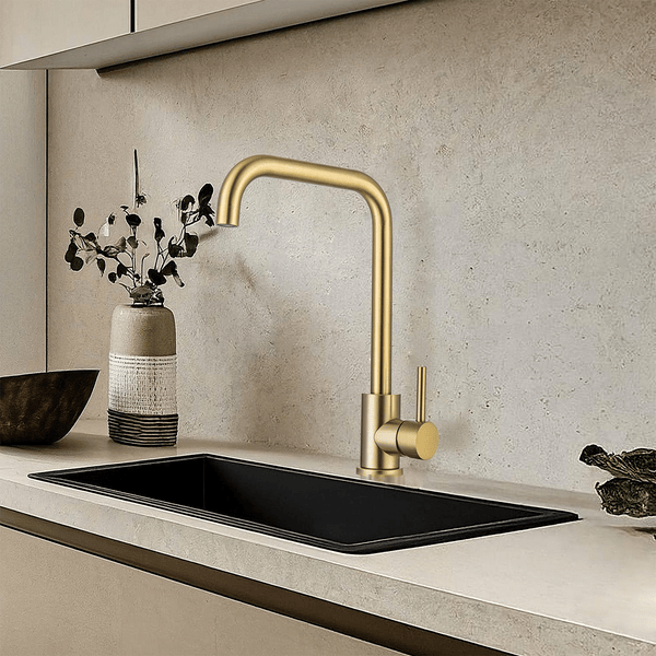 Moderne Küchenarmatur in gebürsteter Metalloptik montiert an einem schwarzen Spülbecken vor einer neutralen Küchenrückwand.