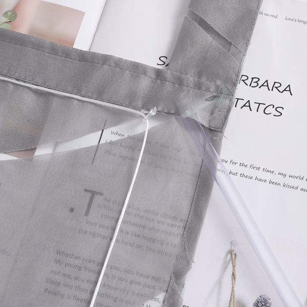 Detailaufnahme eines grauen Stoffrollos mit Zugschnur