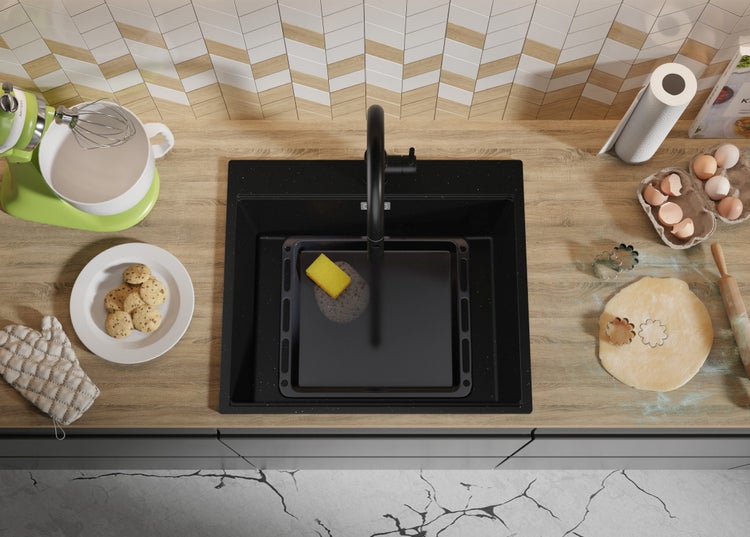 Küchenszene mit Spüle, Armatur, Gebäck und Küchenutensilien auf einer Arbeitsplatte.