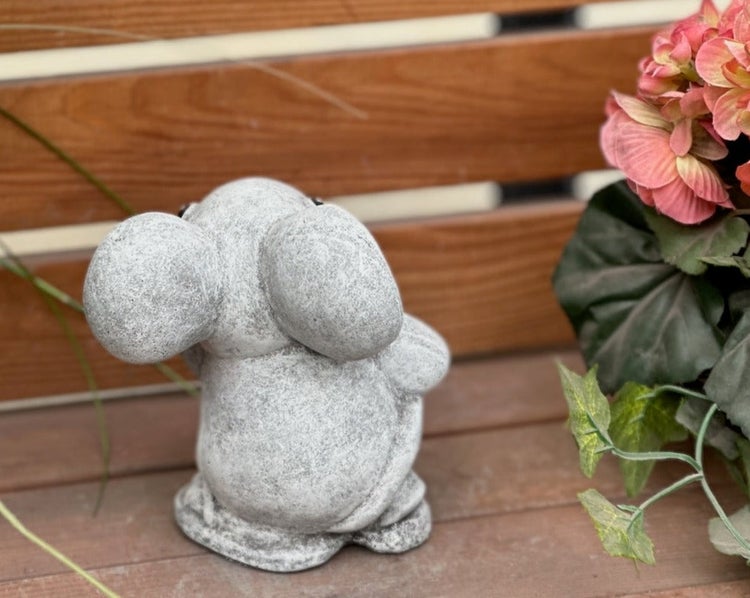 Gartenfigur Elefant in Steinoptik von hinten auf einer Holzterrasse.