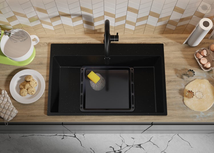 Küchenszene mit Spüle, Armatur, Backblech, Schwamm und Backzutaten auf einer Arbeitsplatte.