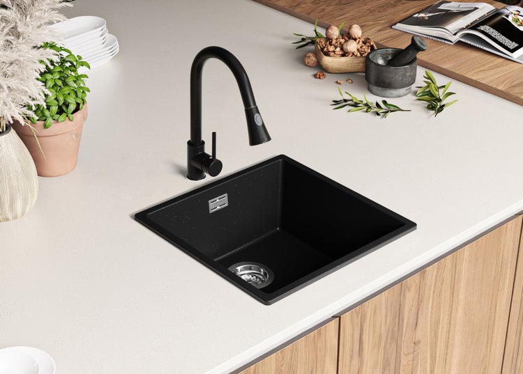 Schwarzes Spülbecken mit Wasserhahn in einer modernen Küche.
