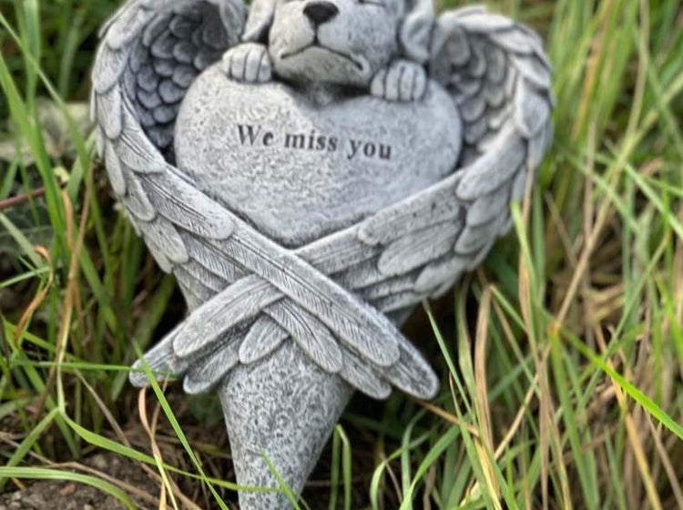 Grabschmuck in Form eines Herzens mit Engelsflügeln und liegendem Hund, mit der Inschrift We miss you, aus wetterfestem Material.