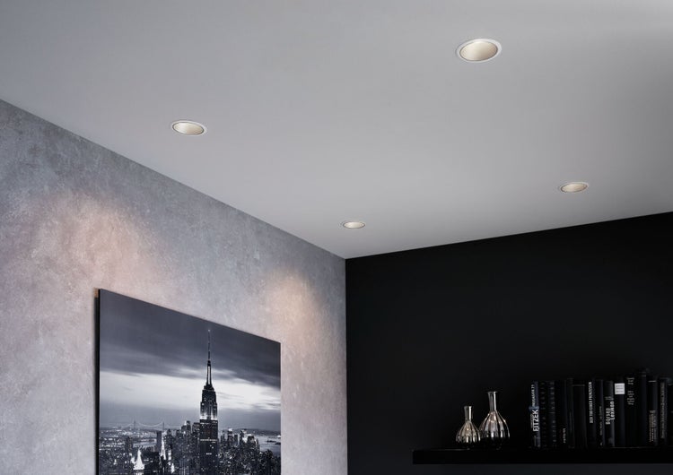 Deckenleuchten in modernem Wohnraum mit Betonwand und Bücherregal