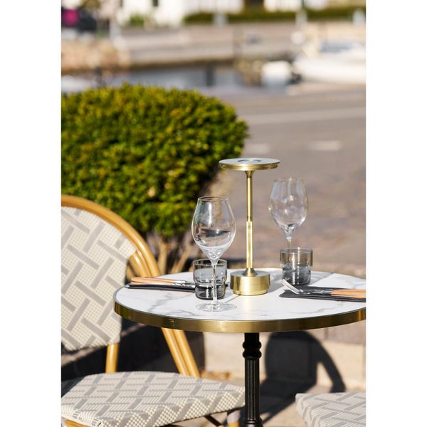 Tisch mit zwei Weingläsern, zwei Wassergläsern und einer Tischleuchte