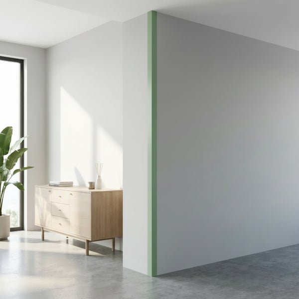 Heller moderner Wohnraum mit Holzanrichte vor einer weißen Wand und einer grünen Akzentkante an einer Wandecke.