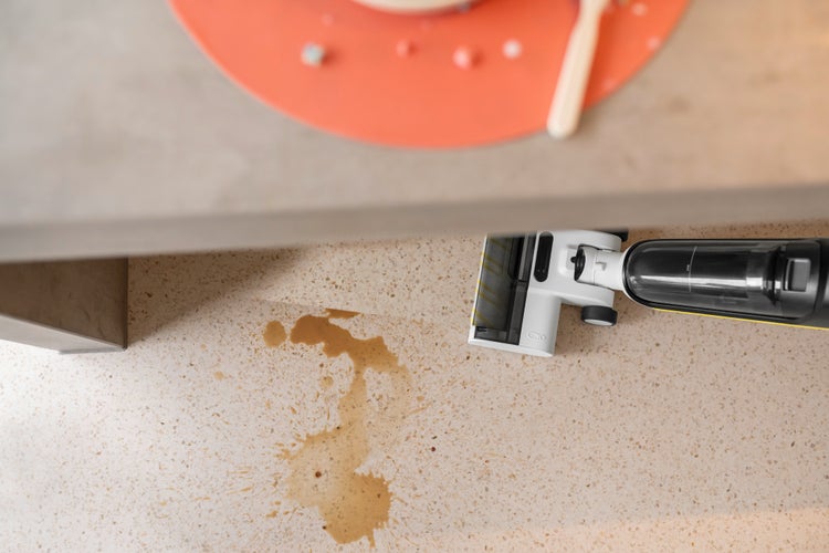 Aufsaugender Bodenreiniger bei der Reinigung einer Flüssigkeit auf dem Boden.