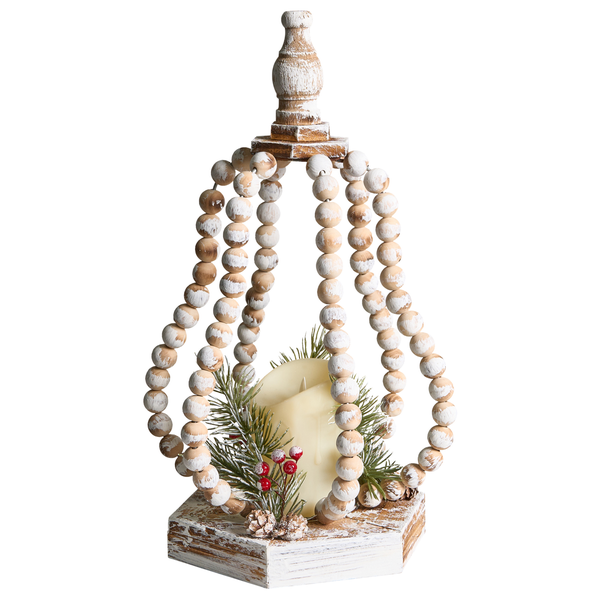 Dekorative Szene mit einem hölzernen Kerzenhalter mit Perlen, einer Tasse Kaffee und Kiefernzapfen auf einem Tisch neben einem Weihnachtsbaum und einem Sofa.