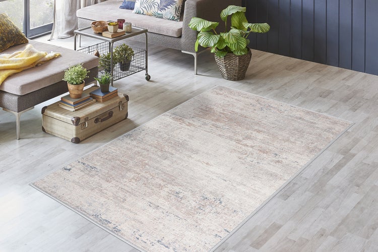 Rechteckiger Teppich mit Vintage-Muster in einem hellen Wohnzimmer auf hellem Laminatboden mit modernen Möbeln und Zimmerpflanzen.