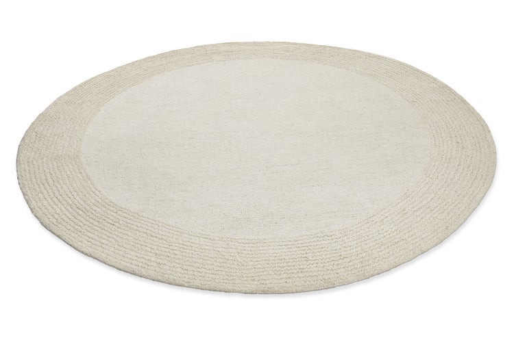 Runder Teppich in Beige mit strukturierter Umrandung.