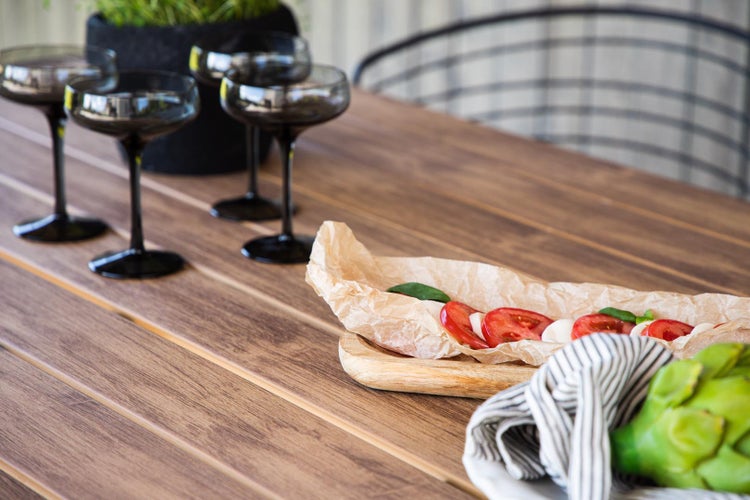 Szene mit vier Gläsern, Speisen und Getränken auf einem Holztisch