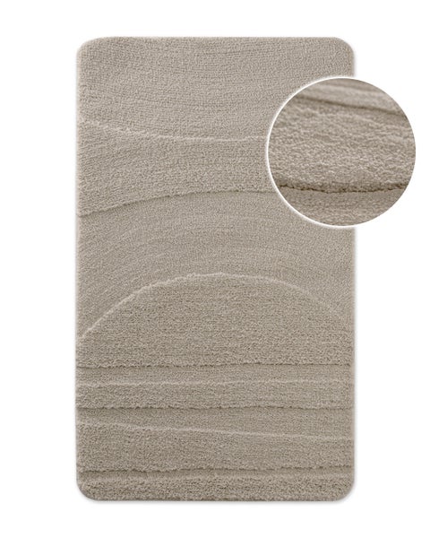 Beiger Badeteppich mit Wellenstruktur und Detailansicht der weichen Oberfläche.