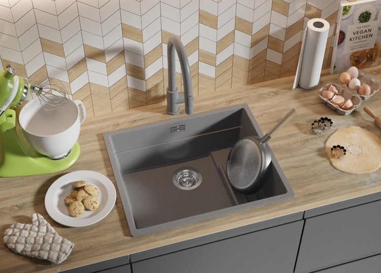 Küchenszene mit Spüle, Armatur, Rührgerät, Zutaten und Backutensilien auf einer Arbeitsplatte.