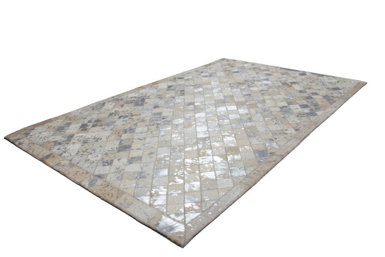 Rechteckiger Patchwork-Teppich aus Kuhfell mit quadratischem Muster und silberfarbenen Akzenten.