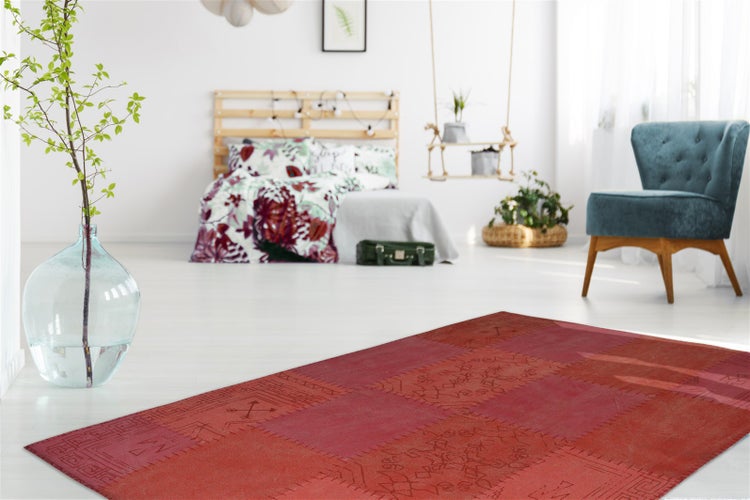 Roter Teppich im Patchwork-Design mit geometrischen Mustern und sichtbaren Ziernähten.