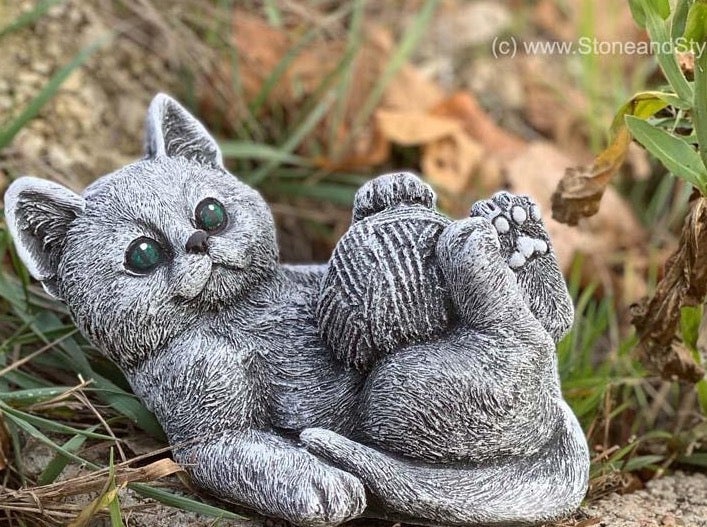 Dekorative Steinguss Gartenfigur in Form einer spielenden Katze mit Wollknäuel für den Außenbereich.