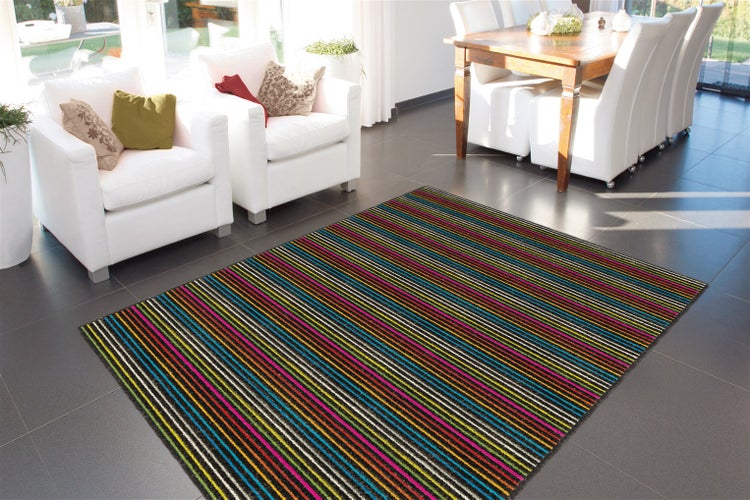 Moderner, bunt gestreifter Teppich in einem hellen Wohnzimmer auf Bodenfliesen.