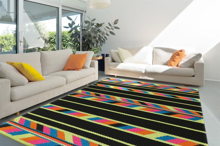 Moderner bunter Teppich mit geometrischem Pfeilmuster in einem hellen, geräumigen Wohnzimmer mit zwei weißen Sofas.