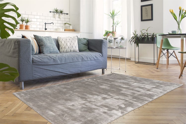 Rechteckiger Hochflor-Teppich in Grau mit schimmernder, weicher Oberfläche.