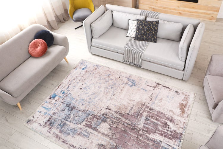 Großer rechteckiger Teppich mit abstraktem Vintage-Muster in einem geräumigen Wohnzimmer mit modernen Sofas und einem Holzfußboden.