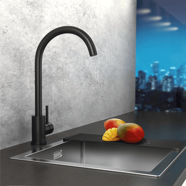 Moderne Küchenarmatur in Schwarz mit Einhebelmischer, montiert an einer Edelstahlspüle mit Abtropfmatte vor einer grauen Betonwand.