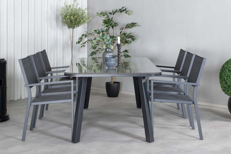 Gartentisch mit Stühlen aus Metall und Glas, dekoriert mit Pflanzen und Kerzen