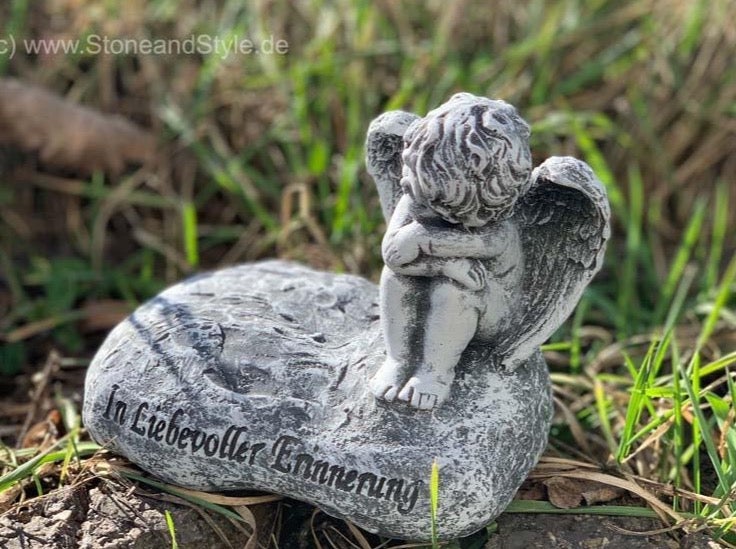 Grabschmuck in Form eines sitzenden Engels auf einem Stein mit der Aufschrift In liebevoller Erinnerung aus wetterfestem Kunststein