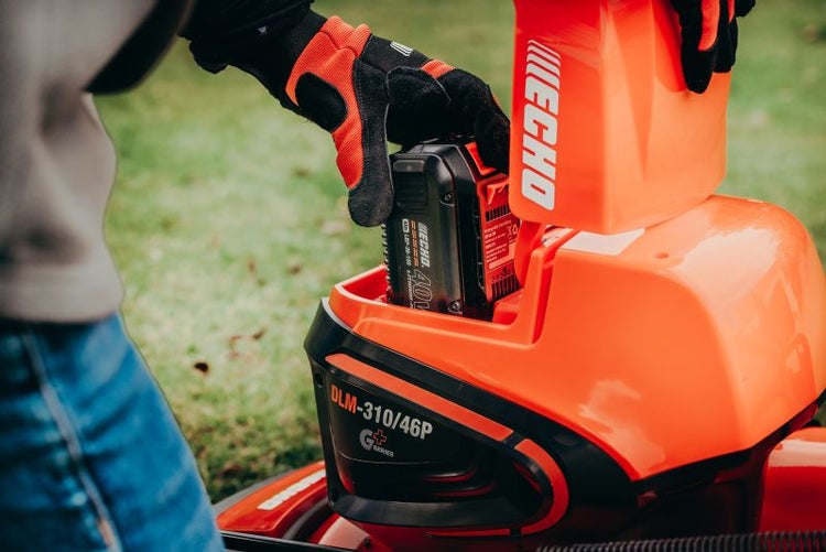 Ein Bediener setzt einen Echo 40V Akku in einen Rasenmäher ein.