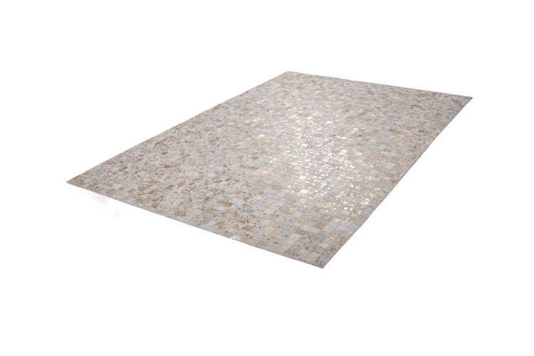 Blauer Teppich mit kleinen Folklore-Motiven auf hellem Holzboden neben einem Bett und einem Beistelltisch in einem hellen Schlafzimmer.