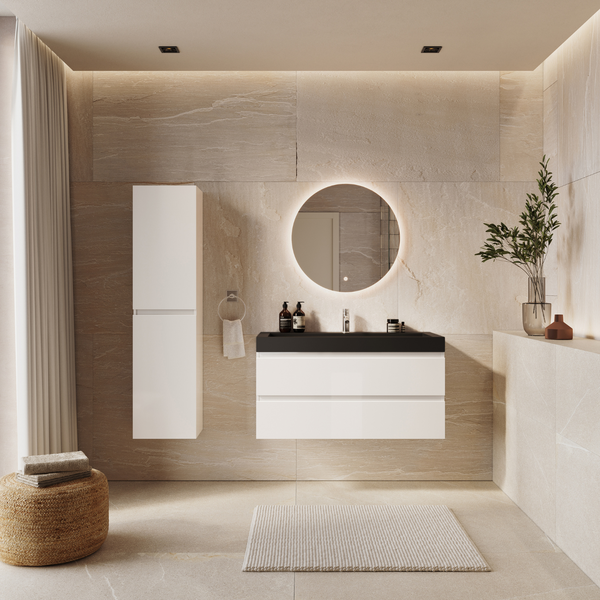 Badezimmer mit Waschbeckenunterschrank, schwarzem Waschbecken, Armatur und beleuchtetem Rundspiegel vor hellen Fliesen mit Natursteinoptik.