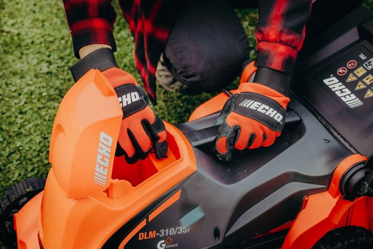 Detailansicht eines Rasenmähers während der Inbetriebnahme mit Schutzhandschuhen