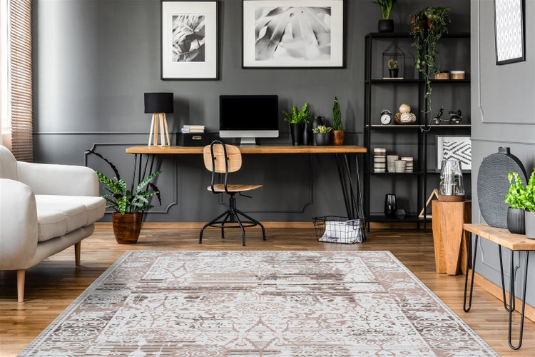 Modernes Arbeitszimmer mit einem großflächigen, gemusterten Teppich auf Holzfußboden, einem Holzschreibtisch und dunklen Wänden mit Wandbildern.