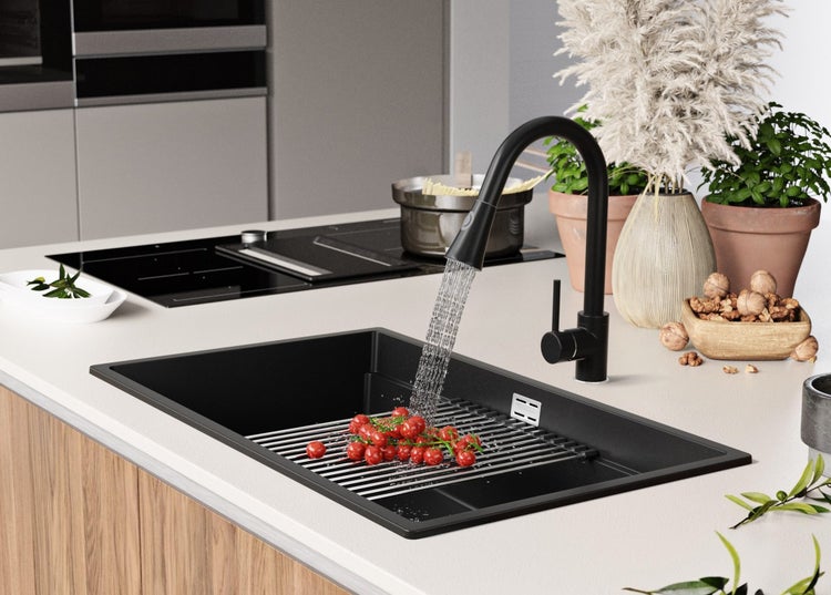 Küchenszene mit schwarzem Spülbecken, Armatur und Abtropfgitter