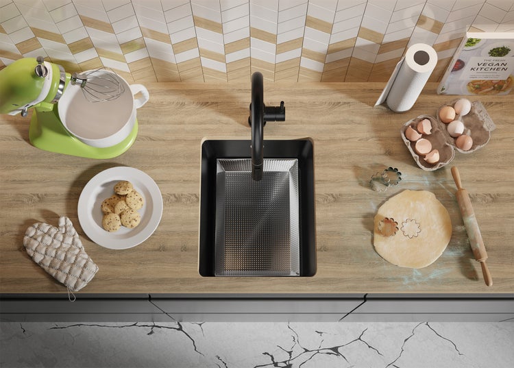 Küchenszene mit Spüle, Armatur, Küchenmaschine, Keksen, Kochbuch und Backutensilien auf einer Arbeitsplatte