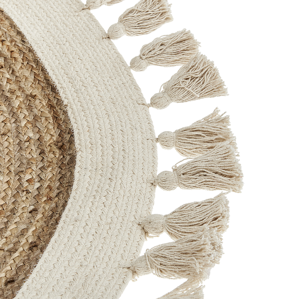 Detail eines runden Teppichs aus Jute und Baumwolle mit geflochtenem Rand und Quasten.