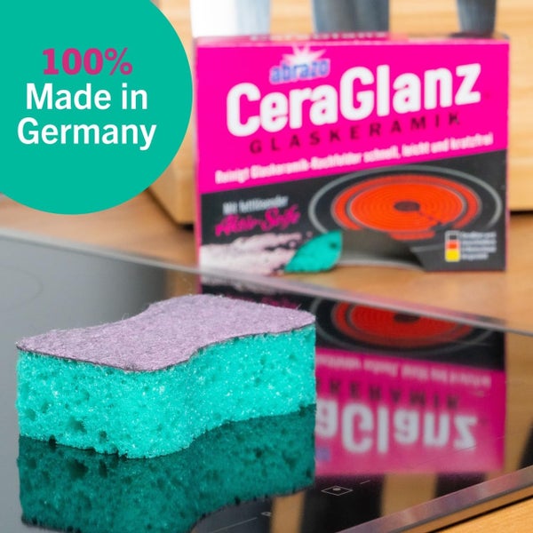 Reinigungsschwamm abrazo CeraGlanz auf einem Glaskeramikkochfeld mit Verpackung und Siegel zu 100 Prozent in Deutschland hergestellt.