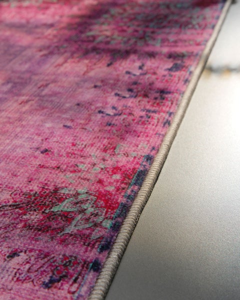 Teppich mit ornamentalem Muster im Vintage-Stil und gekettelter Kante.