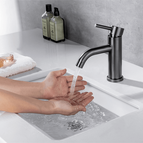Moderne Einhand Waschtischarmatur mit fließendem Wasser über den Händen in einem Badezimmer