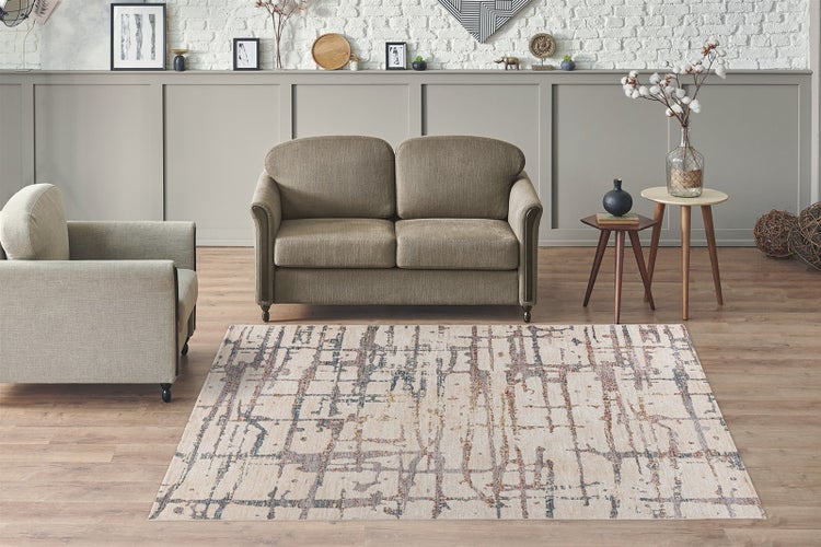 Rechteckiger Teppich mit abstraktem Gittermuster in einem modern eingerichteten Wohnzimmer mit Sofa und Sessel auf Holzfußboden.