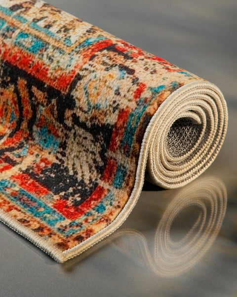 Eingerollter Teppich mit Vintage-Muster in Rot, Blau und Beige, mit geketteltem Rand und weichem Flor.