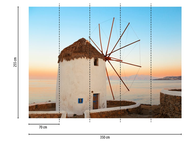 Fototapete mit griechischer Windmühle vor Küstenlandschaft bei Sonnenuntergang, Breite 350 Zentimeter mal Höhe 255 Zentimeter.