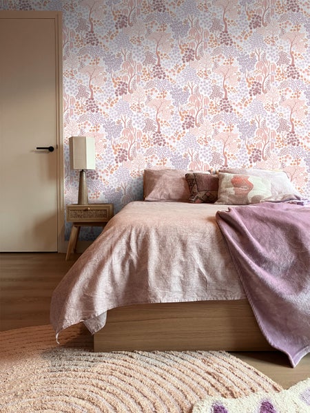 Schlafzimmer mit Bett, Nachttischlampe und Tapete mit Baumdesign